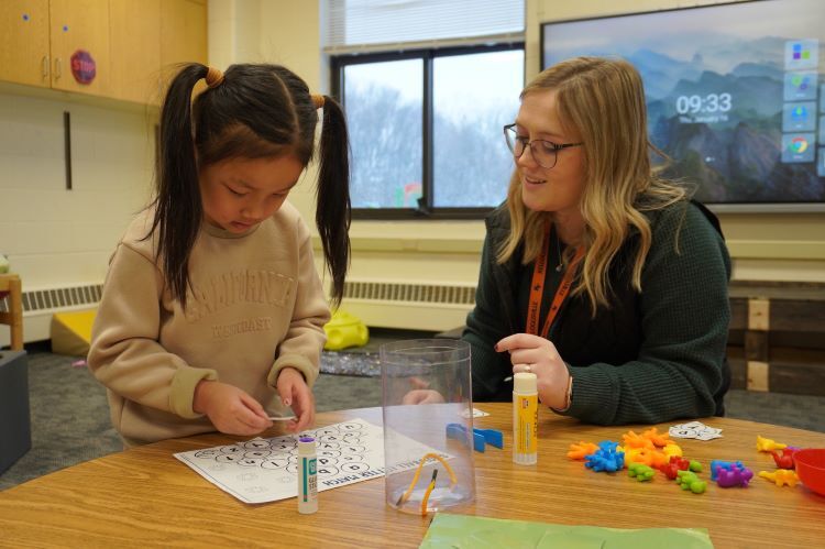 A teacher and student working together at a table.